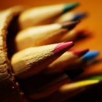 A close-up of sharpened colored pencils showcasing a vibrant array of colors and detailed wood texture.